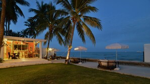 A beachfront property with a bar area, outdoor seating, and umbrellas. - The Hen Hua Hin Private Beach Villa (Hua Hin)