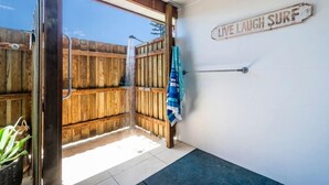 A wooden deck with a wooden fence, a towel hanging on a rack, and a sign that reads "LIVE LAUGH SURF". - Captains Bridge Wooli (Wooli)