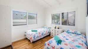 A room with two beds, a small white dresser, and a window with blinds. - Captains Bridge Wooli (Wooli)