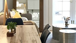 Una sala moderna con una mesa de comedor de madera, un sofá y una mesa auxiliar.