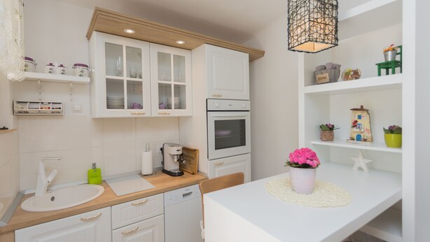 A modern kitchen with white cabinetry, a built-in oven, and a coffee machine. - Small house in the old town & patio - Dama (Split)