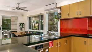 Eine moderne Küche mit schwarzem Arbeitsplatz, Edelstahlgeräten und Holzausstattung.