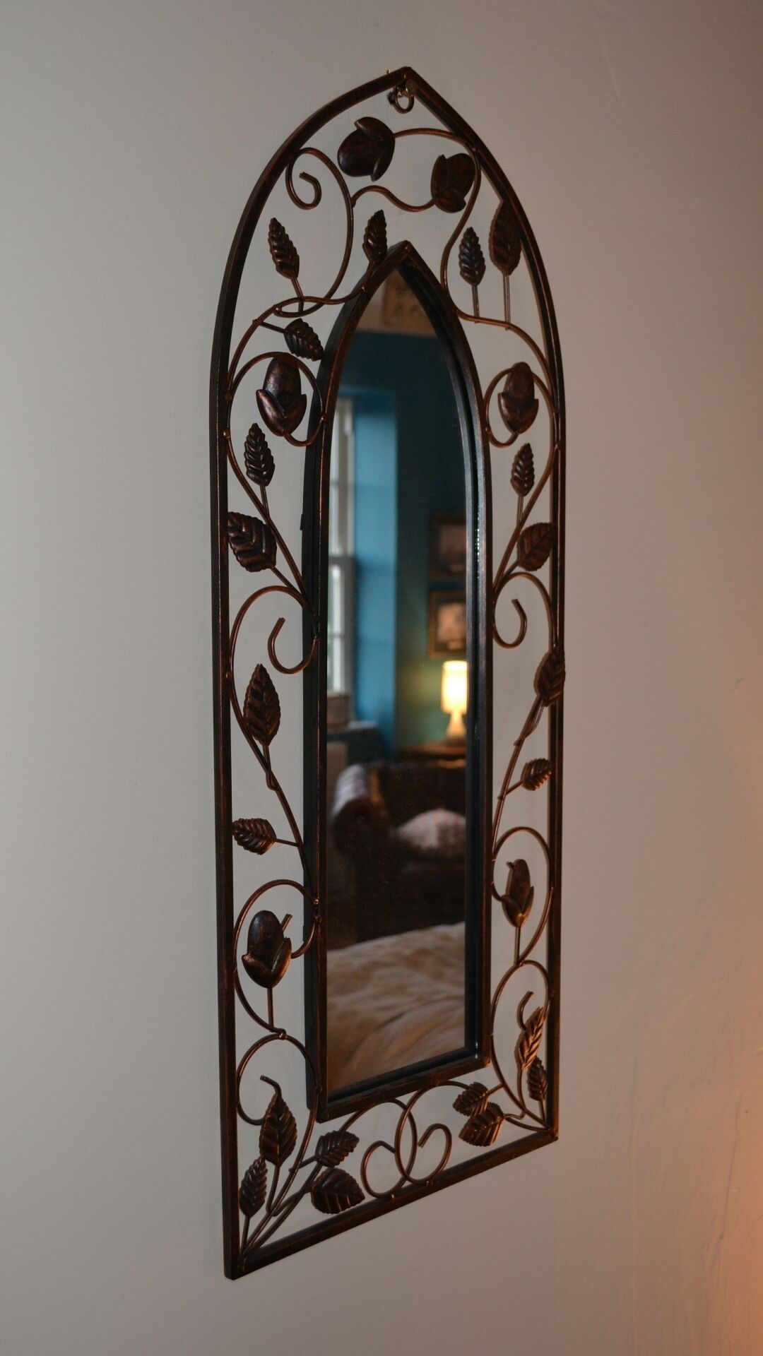 A wall-mounted mirror with an ornate, leaf-decorated frame.