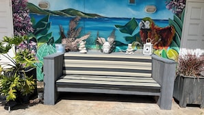 A set of outdoor steps leading to a mural with a parrot and a beach scene. - Charming Poolside Studio with Private Porch in Curaçao (Willemstad)