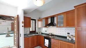 Una cucina con mobili in legno, un piano cottura nero e uno schienale piastrellato.