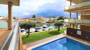 A pool area with a view of boats docked in the marina.