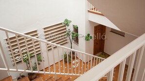 A staircase with white railings and a wooden floor, leading to a room with a door and a window. - Obelisc-1, 2 DB apartment near the beach (Can Picafort)