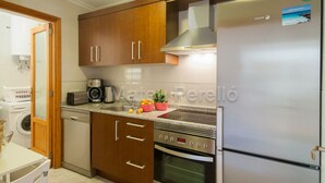 A modern kitchen with wooden cabinets, a stainless steel refrigerator, and an oven. - Obelisc-1, 2 DB apartment near the beach (Can Picafort)