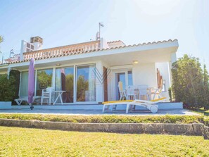 Una moderna casa a due piani con un balcone, ampie finestre e una zona piscina.
