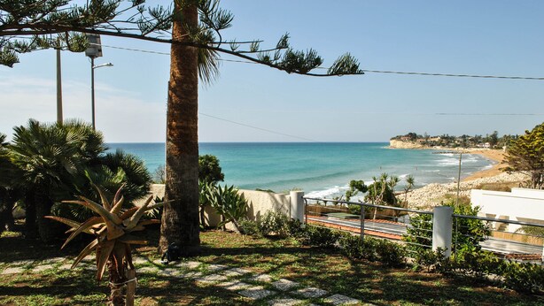 A coastal view with a paved walkway, palm trees, and a beach in the background. - villas overlooking the sea (Gallina)