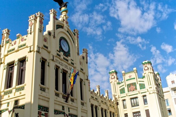 A historic building with ornate architectural details, including a clock tower and flags.