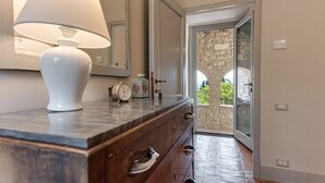 A bathroom with a marble countertop, a white lamp, a clock, and a decorative box.