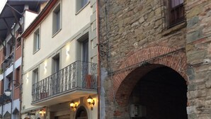Ein Gebäude mit einer Steinaußenwand, einer Holztür und einem Balkon mit schmiedeeisernen Geländern.
