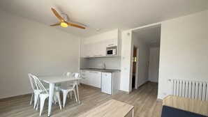 Une cuisine moderne avec des armoires blanches, un four à micro-ondes et un ventilateur de plafond.