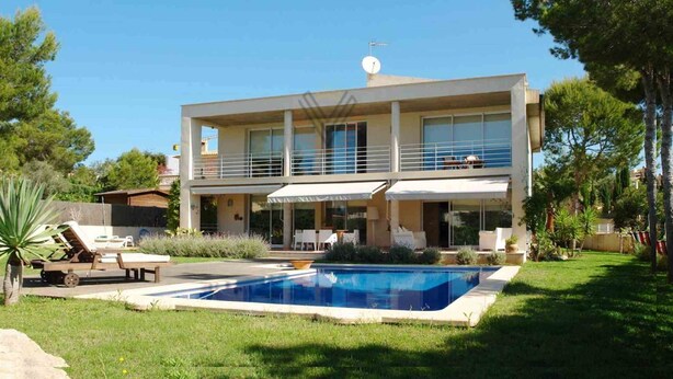 Ein modernes Haus mit zwei Etagen, einem Swimmingpool, Gartenmöbeln und einem gepflegten Garten.