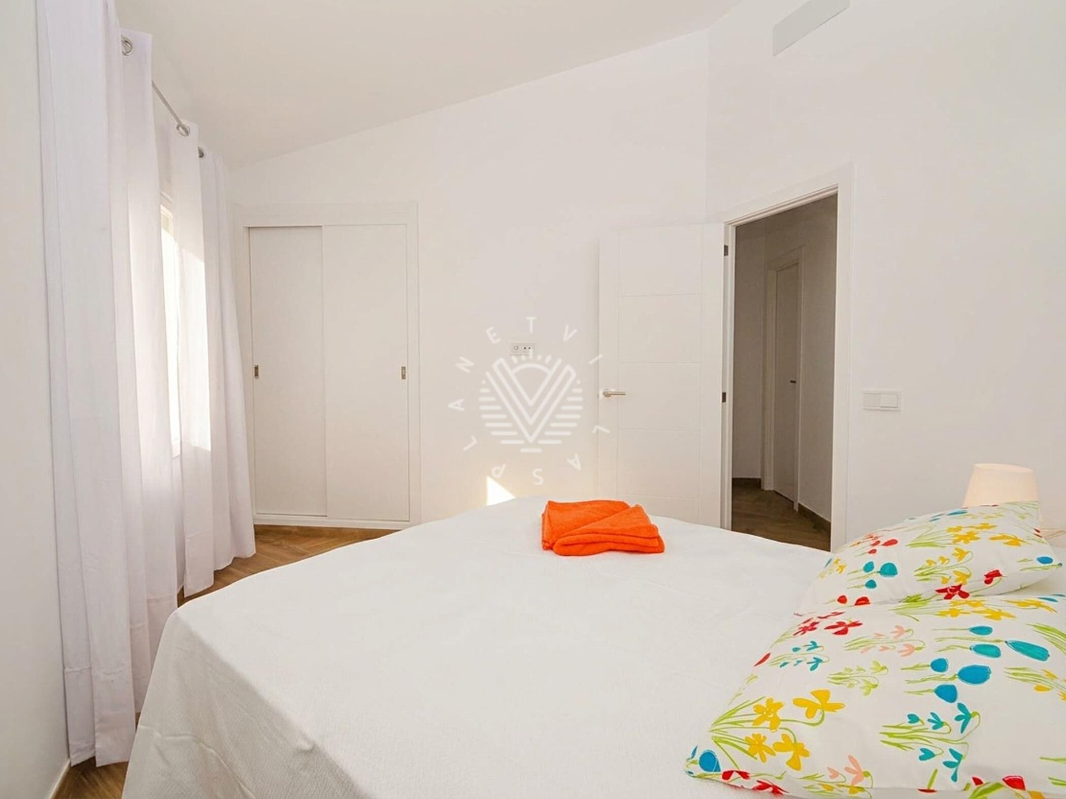 Una habitación de hotel con una cama, una puerta y una ventana con cortinas.