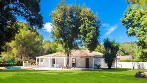 Une maison dotée d’un patio, d’une piscine et d’une pelouse bien entretenue.