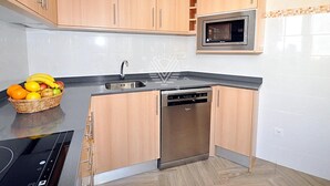 Une cuisine moderne avec des meubles en bois, un four à micro-ondes encastré et un lave-vaisselle.