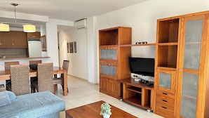Ein Wohnzimmer mit einer Couch, einem Couchtisch, einer TV-Konsole und Holzkästen.