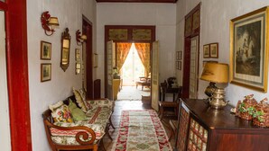 A hallway with a sofa, a lamp, and a painting on the wall.