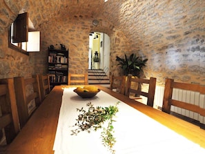 Enjoy meals in this cozy dining area with a long table, wooden benches, and a bookshelf.