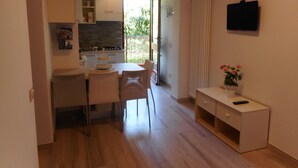 Una cocina compacta con comedor, una mesa pequeña y un armario.
