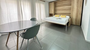 A modern room with a bed, a table, and chairs. - Agi Arago 151 Apartamento for rent in Roses Girona. (Rosas / Roses)