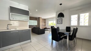 A modern kitchen with a dining area, a sofa, and a dining table with chairs. - Agi Drugstore AD Apartamento for rent in Roses Girona. (Rosas / Roses)