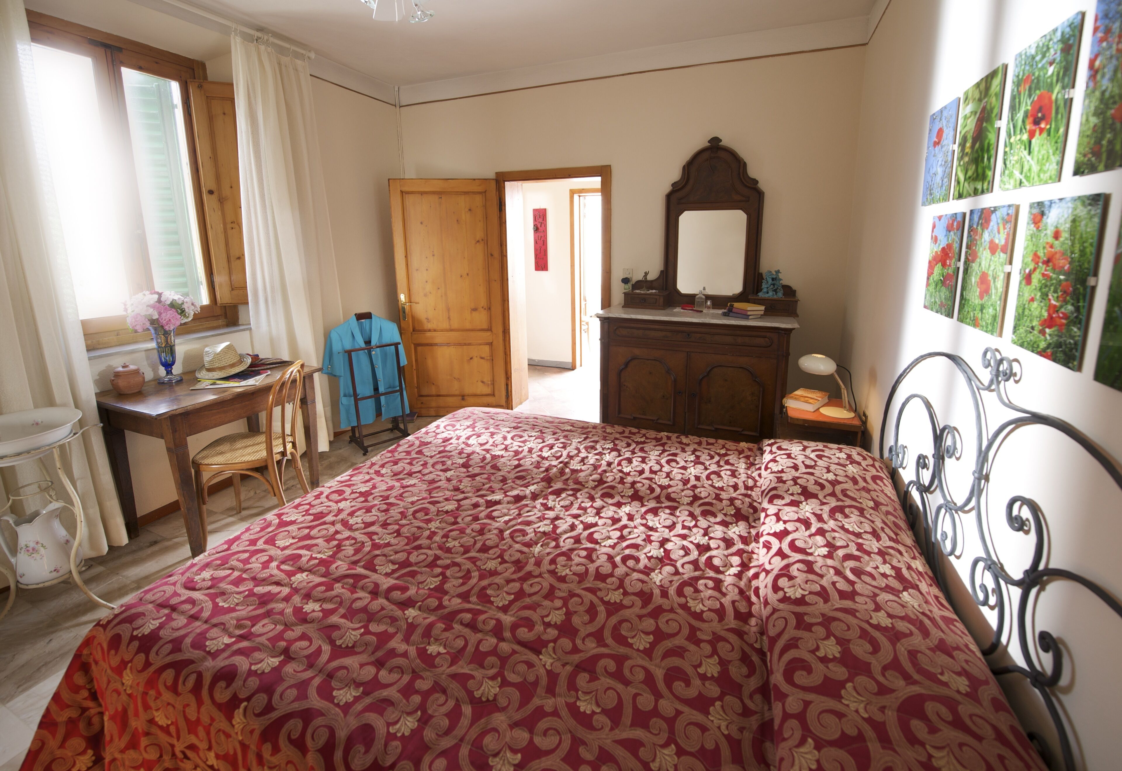 Un dormitorio con una cama grande, un aparador de madera, un espejo y un escritorio con una silla.