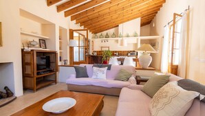A cozy living room with a wooden ceiling, a sofa set, a coffee table, and a TV stand. - Private retreat with pool near the sea (Son Servera)