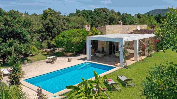 A modern pool area with a clear blue pool, surrounded by lush greenery and a stone building. - Private retreat with pool near the sea (Son Servera)