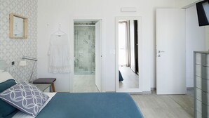 Ein Schlafzimmer mit Bett, Nachttisch und einem Kleiderhaken.