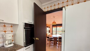A kitchen with white cabinets, a coffee maker, and a microwave. - Agi Can Parramon A Apartamento for rent in Roses Girona. (Rosas / Roses)