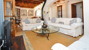 A cozy living room with a glass coffee table, white sofas, wooden beams, and framed pictures on the walls. - Can Teulada, private pool Pollensa 12 persons (Pollensa)