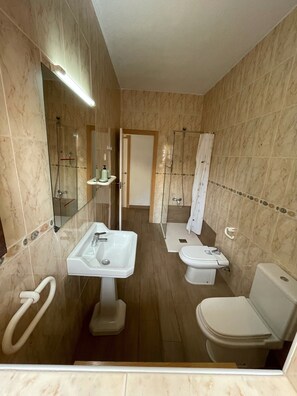 Een douche, een haardroger, een bidet, handdoeken