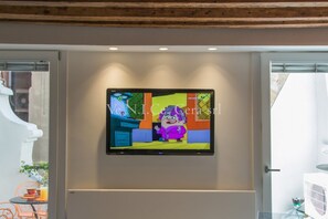 A flat-screen TV mounted on a wall in a room with a wooden ceiling. - Ve.N.I.Ce. Cera Casa Del Giglio (Venezia)