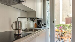 Une cuisine dotée d’un plan de travail noir, d’un évier en acier inoxydable et d’une machine à café.