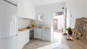 A modern kitchen with white cabinetry, a built-in oven, and a dishwasher. - Ran de Mar, house directly on the beach with spectacular sea views (Alcúdia)