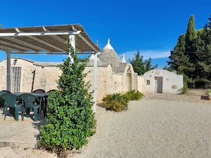 A stone building with a covered patio and outdoor seating. - Antico Trullo Ulmo - Private pool + Wi-Fi (Ceglie Messapica)