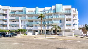 A multi-story hotel with balconies, a palm tree in the foreground, and a clear blue sky. - ROYAL MARINE 2 240 Roses (Rosas / Roses)