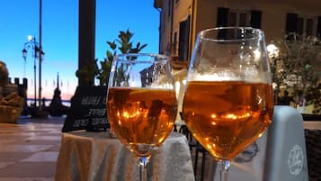 Two glasses of amber liquid on a table with a menu and a sign in the background.