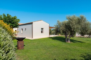 A modern house with a white exterior, a tiled roof, and a well-maintained lawn. - Beautiful villa with a sea-view terrace and private garden in Scicli. Shared pool - Dicasainsicilia (Scicli)