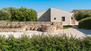 Une maison moderne avec un mur en pierre et un jardin.