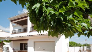A two-story house with a white exterior, a garage, and a balcony. - Villa with private swimming pool.HUTG-015590 (l'Escala)