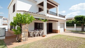 A two-story house with a balcony, a stone pillar, and a patio with outdoor furniture. - Villa with private swimming pool.HUTG-015590 (l'Escala)