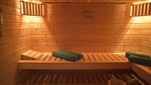 Una sauna de madera con bancos y toallas.