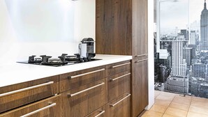 Una cocina moderna con campana de acero inoxidable, armarios de madera y encimera blanca.