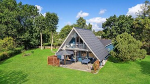 A two-story house with a balcony, surrounded by a well-maintained lawn and trees. - 3 bedroom gorgeous home in Rudkøbing (Rudkøbing)