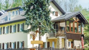 Een twee verdiepingen tellend huis met een balkon en een houten omheining.
