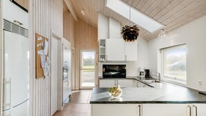 A modern kitchen with a central island, white cabinetry, a built-in oven, and a hanging light fixture. - 4 bedroom nice home in Odder (Odder)
